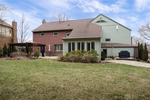 rear view of property with a patio, a lawn, and a pergola