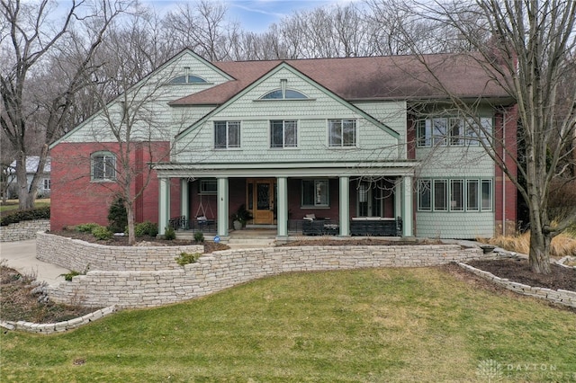 rear view of property featuring a yard and a porch