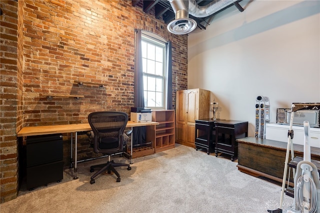 office with light colored carpet and brick wall