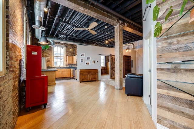 interior space with sink, light wood-type flooring, brick wall, and a barn door