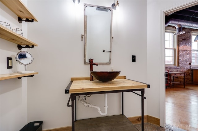 bathroom with sink and brick wall