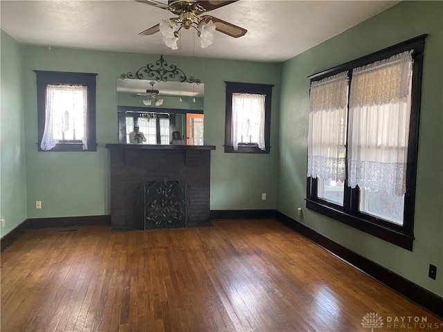 unfurnished living room featuring a brick fireplace, ceiling fan, and hardwood / wood-style floors