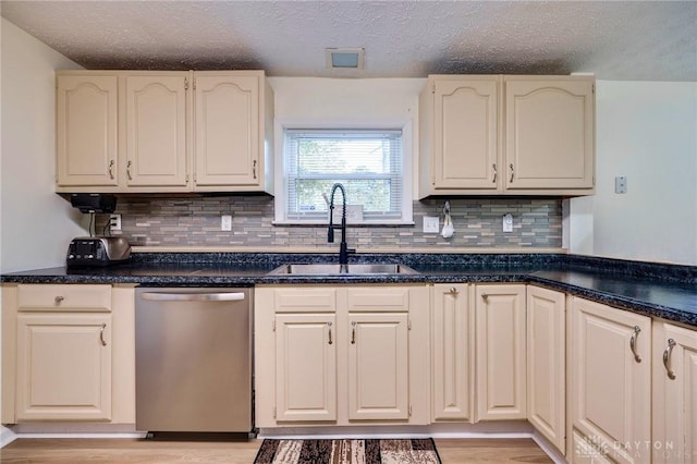 kitchen featuring sink, light hardwood / wood-style floors, dishwasher, and a textured ceiling