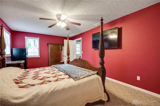 bedroom featuring ceiling fan, carpet floors, and a textured ceiling