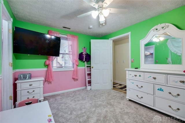 bedroom featuring a textured ceiling, ceiling fan, and light colored carpet