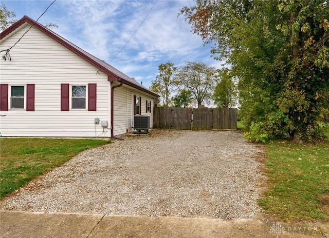 view of home's exterior with central air condition unit and a yard