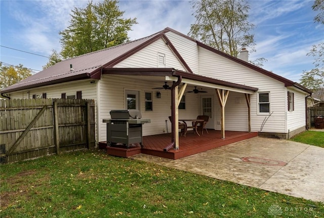 rear view of house featuring a lawn, a deck, ceiling fan, and a patio