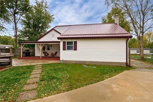 rear view of property featuring a yard and a porch