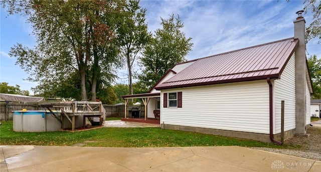 back of property with a lawn and a fenced in pool