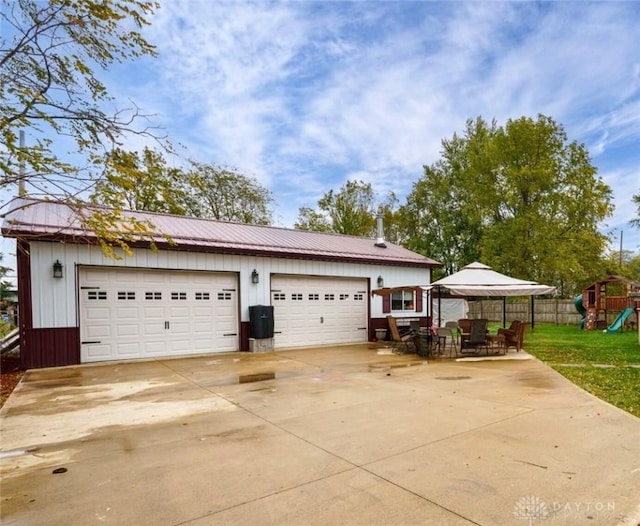 exterior space featuring a playground, a garage, and an outbuilding