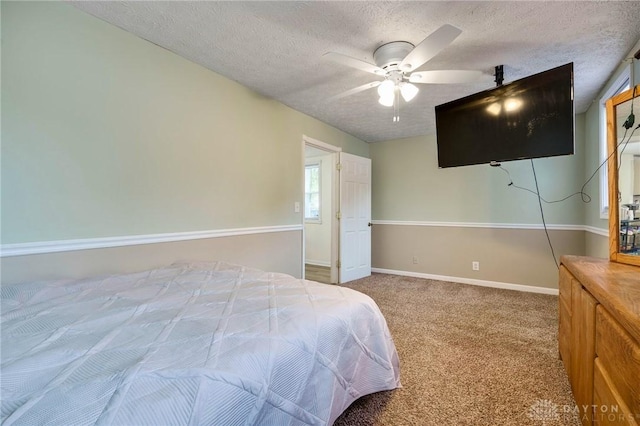 carpeted bedroom with ceiling fan and a textured ceiling