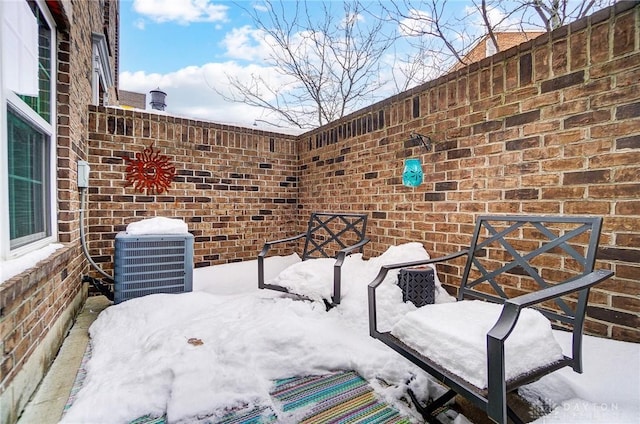 snow covered patio with central AC unit