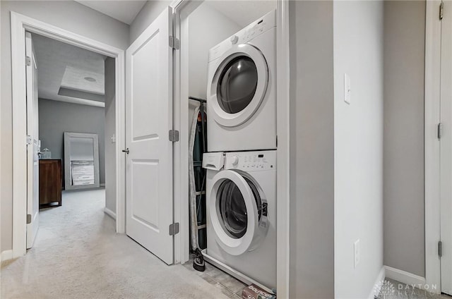 laundry area with light carpet and stacked washer and dryer