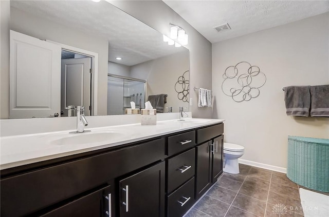 bathroom with toilet, tile patterned floors, vanity, a shower with door, and a textured ceiling