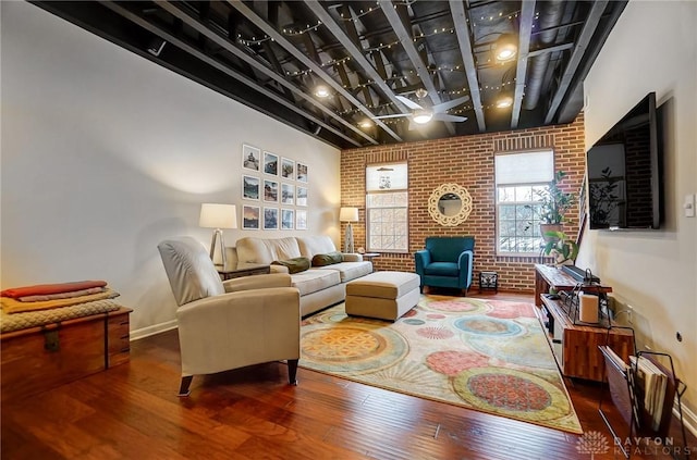 living room featuring dark hardwood / wood-style floors and brick wall