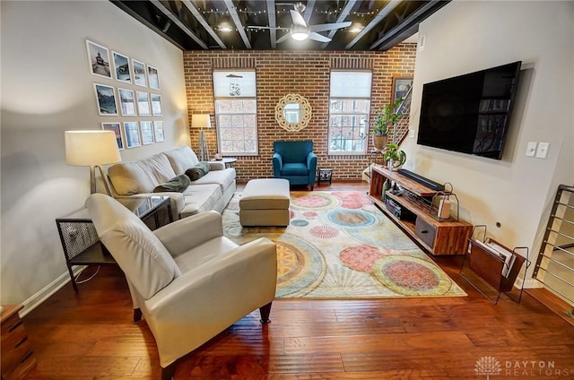 living room with brick wall, ceiling fan, and hardwood / wood-style flooring