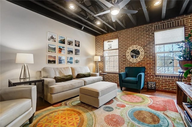 living room featuring brick wall, hardwood / wood-style floors, ceiling fan, and beamed ceiling