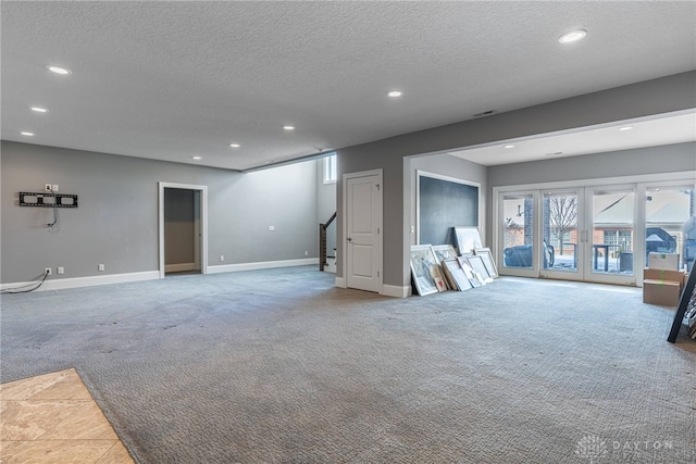 unfurnished living room with a textured ceiling and light carpet