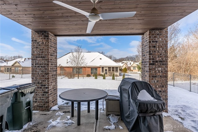 snow covered patio with grilling area and ceiling fan