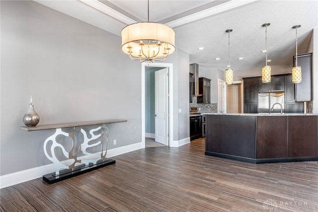 kitchen with built in fridge, pendant lighting, a notable chandelier, and dark brown cabinetry