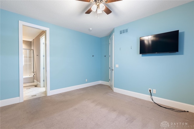 unfurnished bedroom featuring ceiling fan, ensuite bathroom, and light carpet