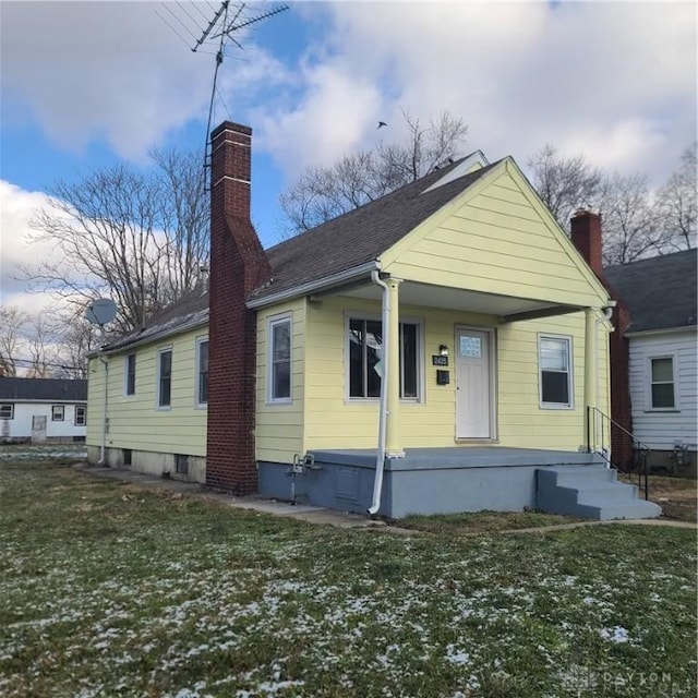 bungalow-style home with a front yard