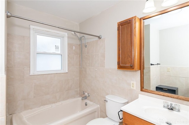 full bathroom featuring toilet, vanity, tile walls, and tiled shower / bath