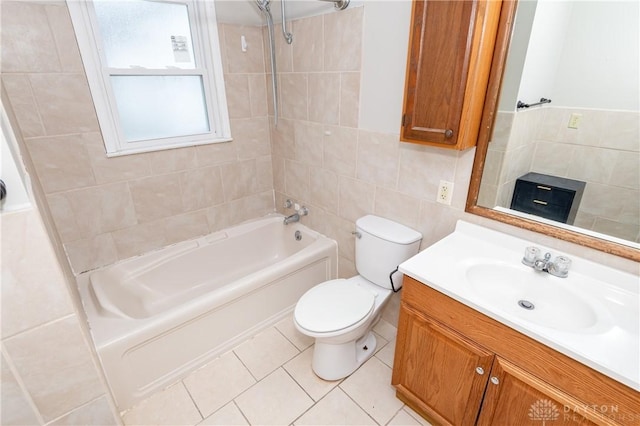 full bathroom with toilet, tile patterned flooring, tile walls, tiled shower / bath combo, and vanity