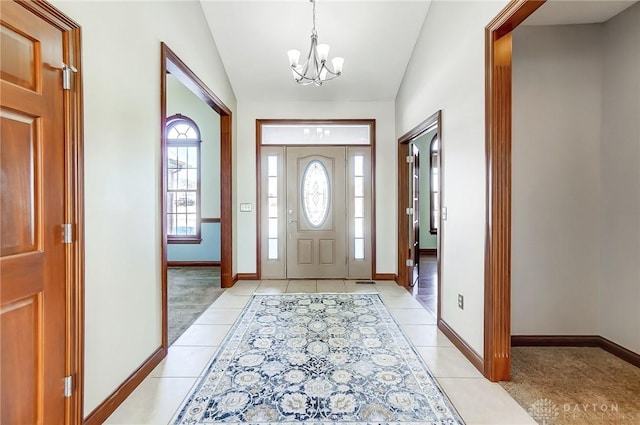 tiled entrance foyer featuring vaulted ceiling and a notable chandelier