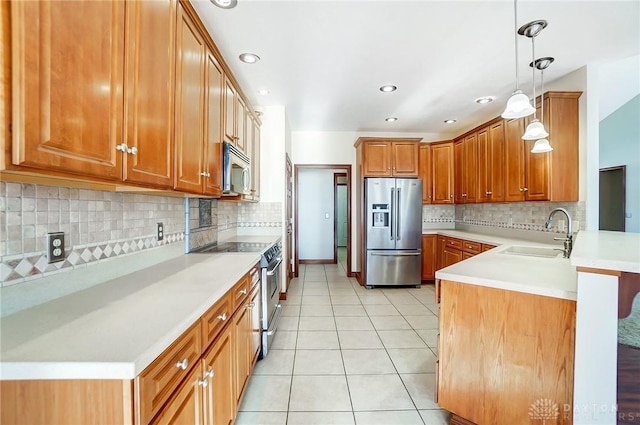 kitchen featuring pendant lighting, sink, light tile patterned floors, kitchen peninsula, and stainless steel appliances