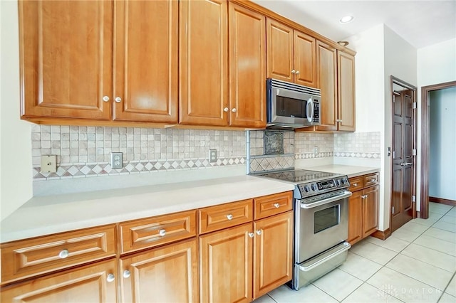 kitchen featuring tasteful backsplash, stainless steel appliances, and light tile patterned floors