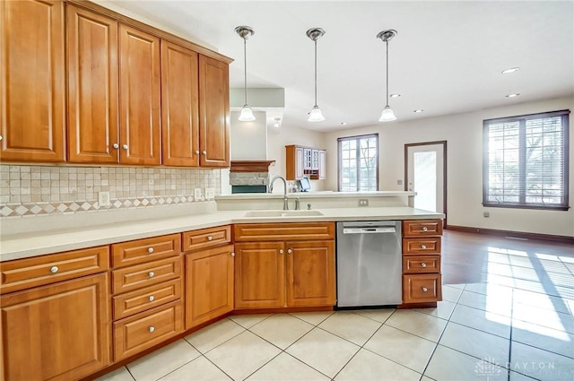 kitchen with sink, decorative backsplash, light tile patterned flooring, decorative light fixtures, and stainless steel dishwasher