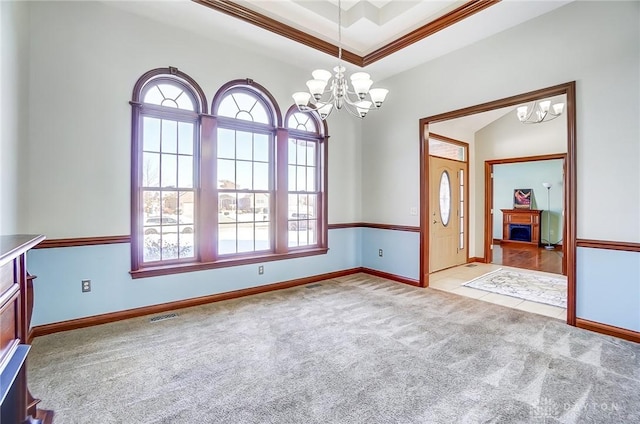 empty room featuring crown molding, light colored carpet, and an inviting chandelier