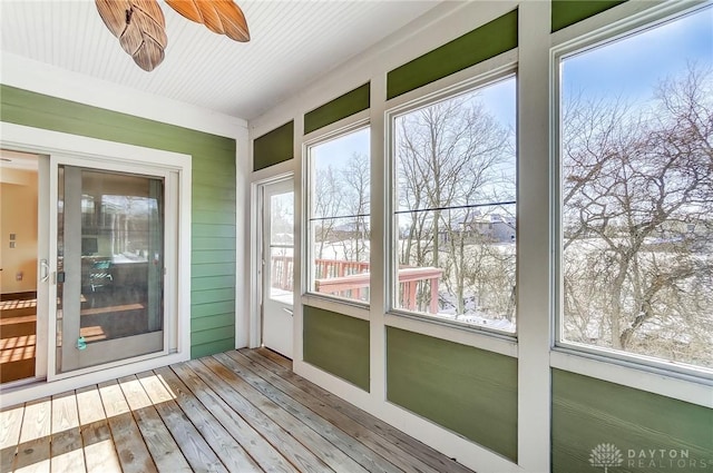 unfurnished sunroom with ceiling fan