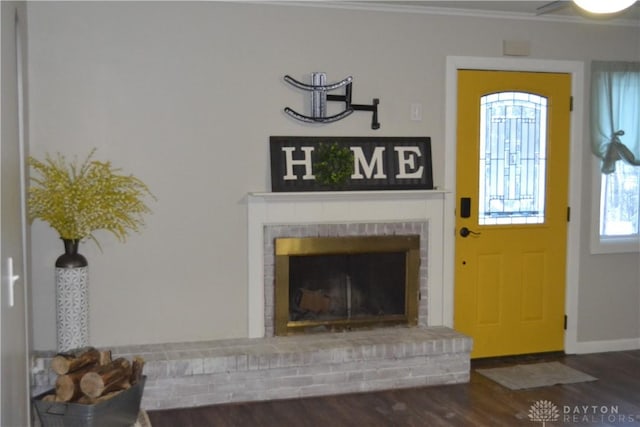 foyer entrance with a fireplace, hardwood / wood-style floors, and ornamental molding