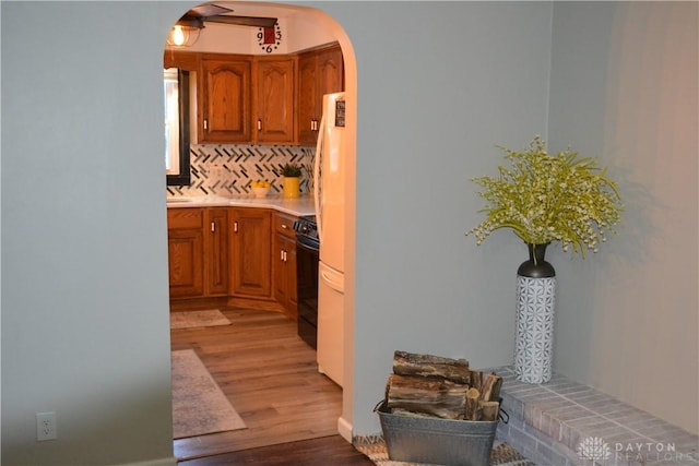 kitchen with hardwood / wood-style floors, range, and tasteful backsplash