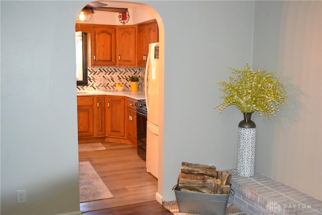 4403 Clayton Rd, Perry Twp, OH 45309 - kitchen featuring arched walkways, wood finished floors, stove, and brown cabinetry