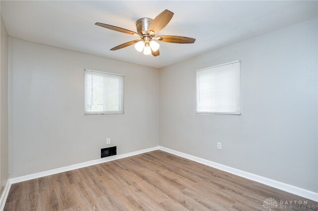 unfurnished room with visible vents, baseboards, light wood finished floors, and ceiling fan