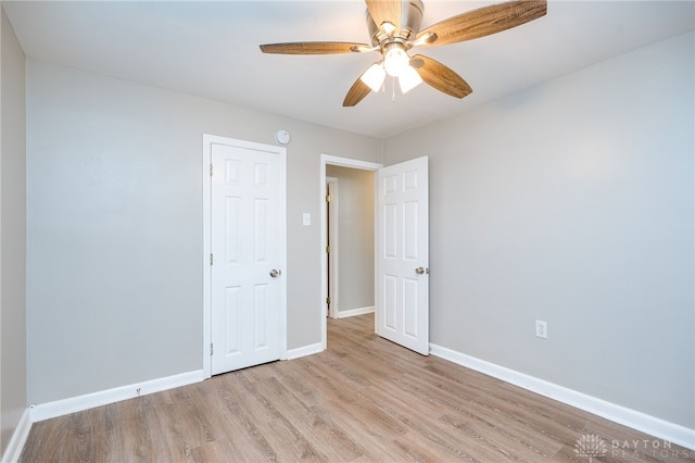 unfurnished bedroom featuring baseboards, wood finished floors, and a ceiling fan