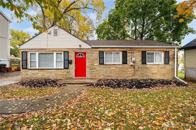 view of front of home featuring stone siding and roof with shingles