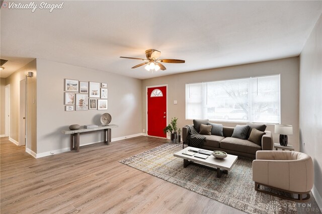 living room with a ceiling fan, wood finished floors, and baseboards