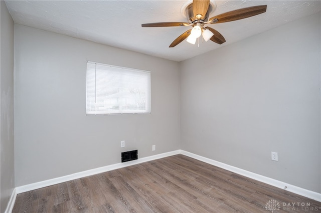 unfurnished room featuring visible vents, baseboards, and wood finished floors