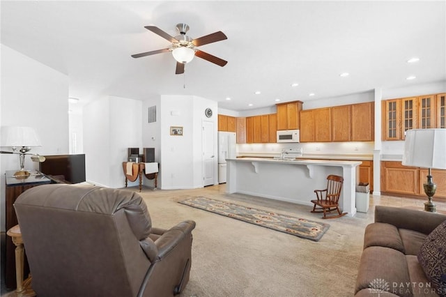 living room featuring ceiling fan, light carpet, and sink