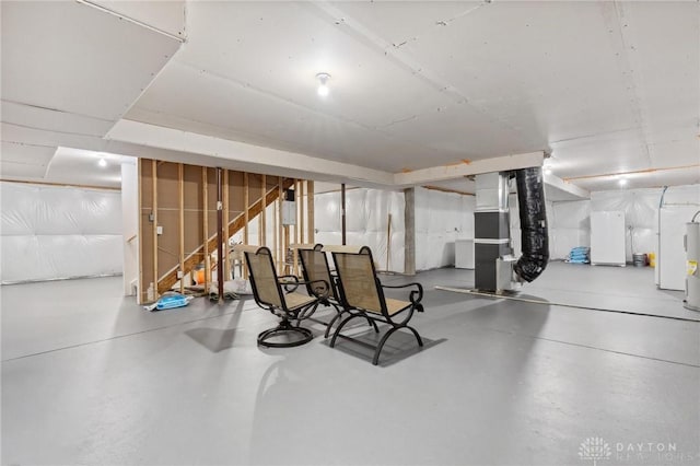 basement with water heater, fridge, and heating unit