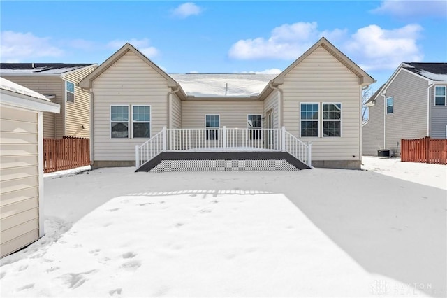 snow covered rear of property featuring a wooden deck