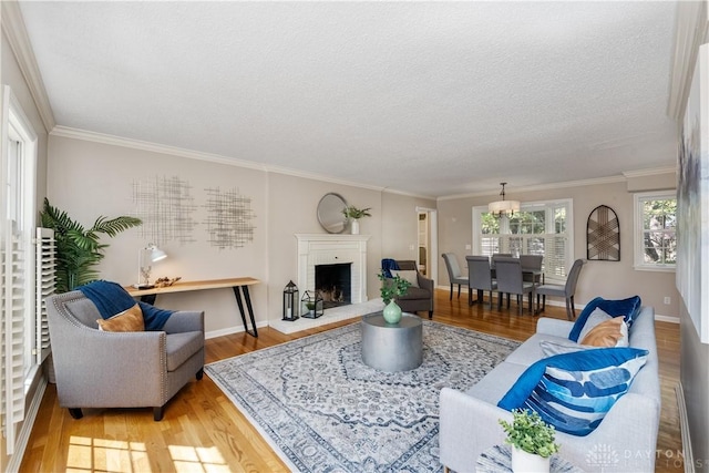 living room featuring hardwood / wood-style floors, a healthy amount of sunlight, a brick fireplace, and ornamental molding