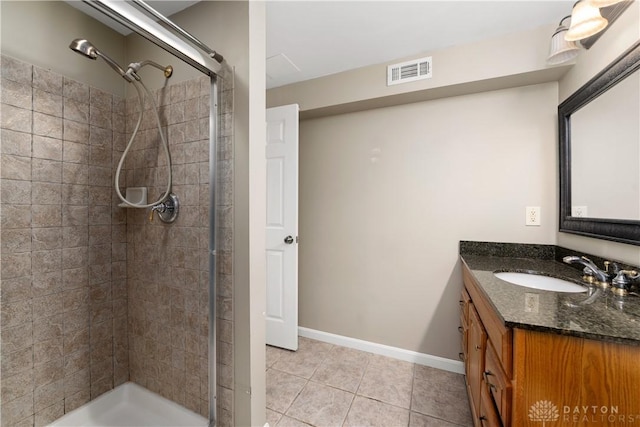 bathroom featuring tile patterned flooring, a shower with shower door, and vanity