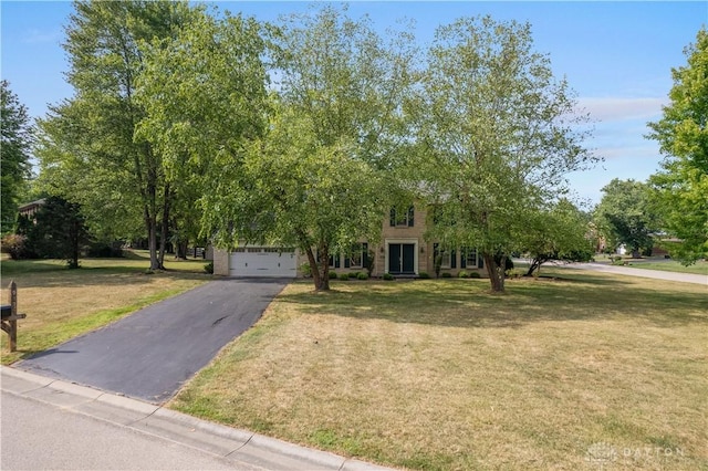 obstructed view of property with a front lawn and a garage