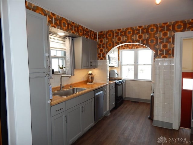 kitchen featuring sink, stainless steel dishwasher, wooden counters, black range with electric cooktop, and gray cabinetry