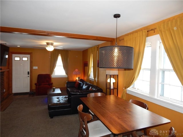 carpeted dining room featuring ceiling fan and beam ceiling